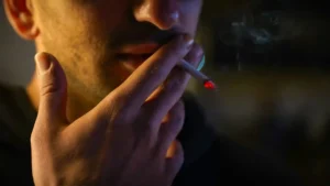 Close-up of a person smoking a cigarette, illustrating the importance of smoking cessation for COPD patients with reduced lung function and chronic respiratory symptoms.